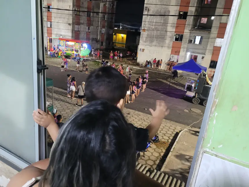 Moradora e seu filho curtindo o Carnaval dos residenciais em seu apartamento 