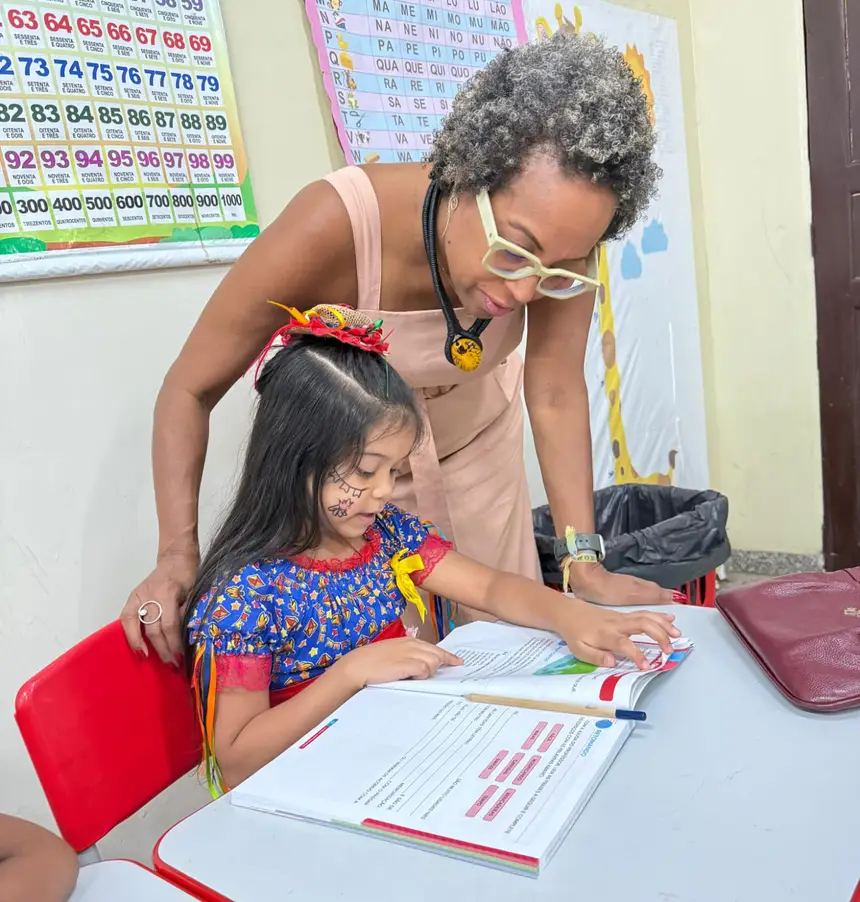 Kátia acompanhando a leitura de aluna da Escola Araçary 