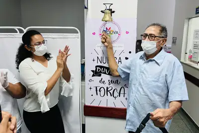 notícia: Com a família e amigos, radialista toca o sino que celebra fim da quimioterapia na unidade oncológica do Governo do Amapá